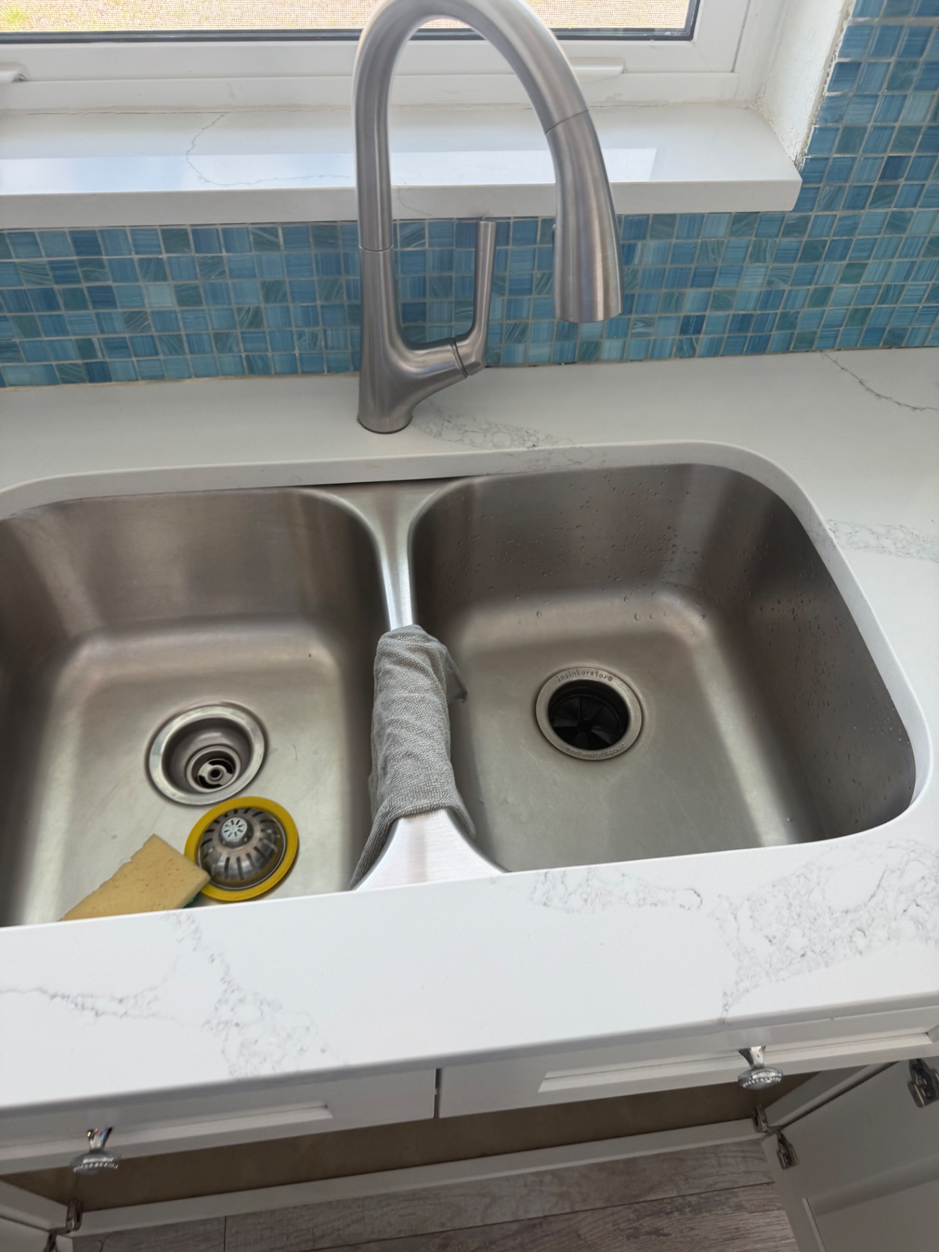 Newly installed stainless double-bowl kitchen sink with brushed-nickel pull-down faucet and InSinkErator disposal by BCS Plumbing